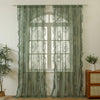 Light green sheer lace curtains hanging over a window with a white frame and wooden floor.