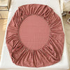 A red and white checkered fitted sheet laid out on a white surface.