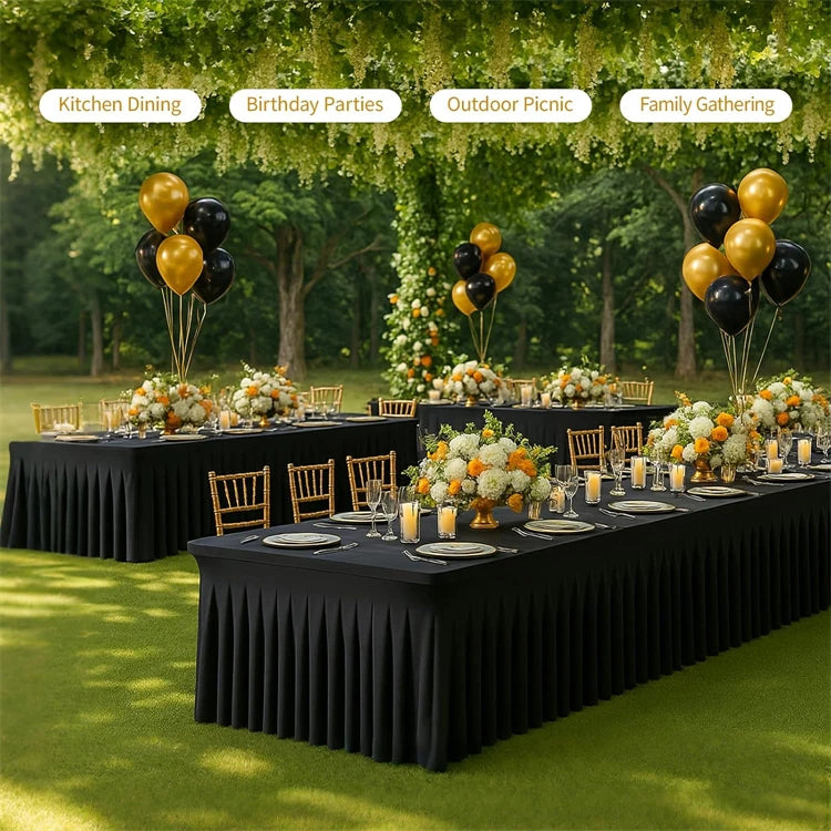 A long black rectangular table set for an outdoor family gathering with floral arrangements and balloons.