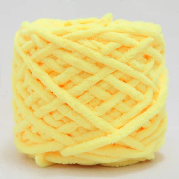 A ball of bright yellow chenille knitting yarn used for hand crafting.