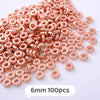 A pile of rose gold colored geometric acrylic beads, 6mm size, for jewelry making.