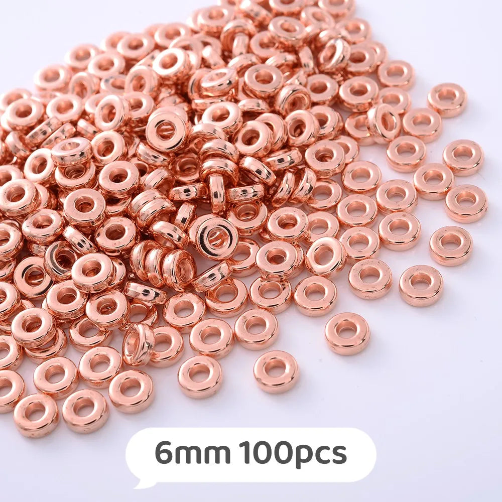 A pile of rose gold colored geometric acrylic beads, 6mm size, for jewelry making.
