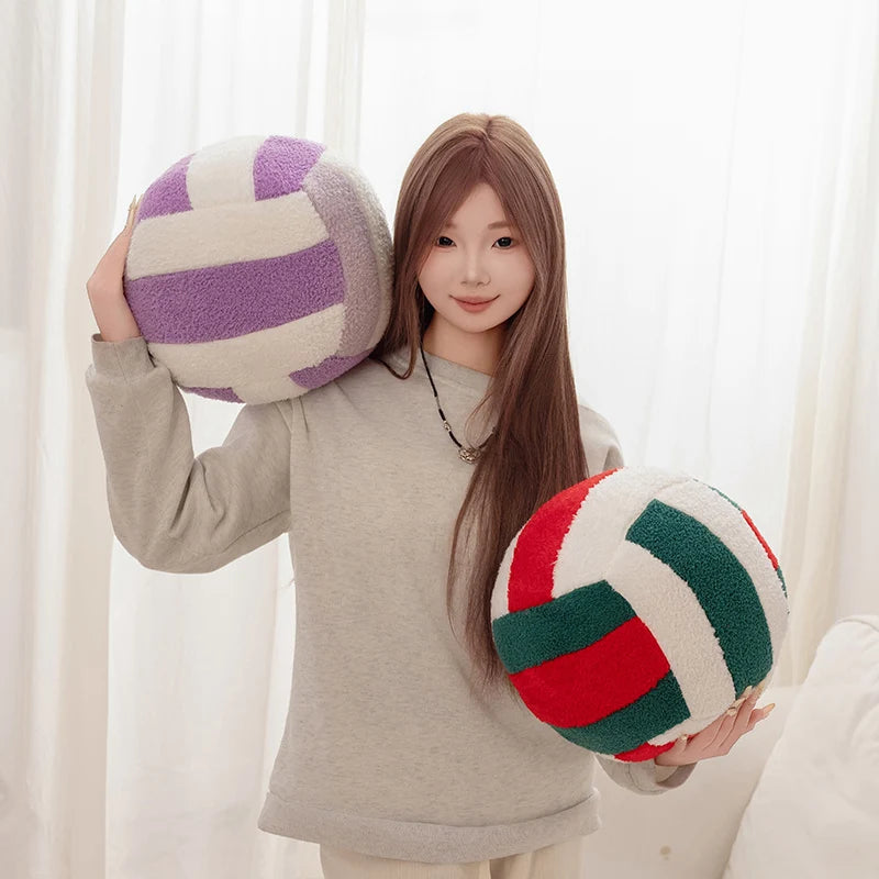 A young woman holds a purple and white striped plush volleyball ball cushion.