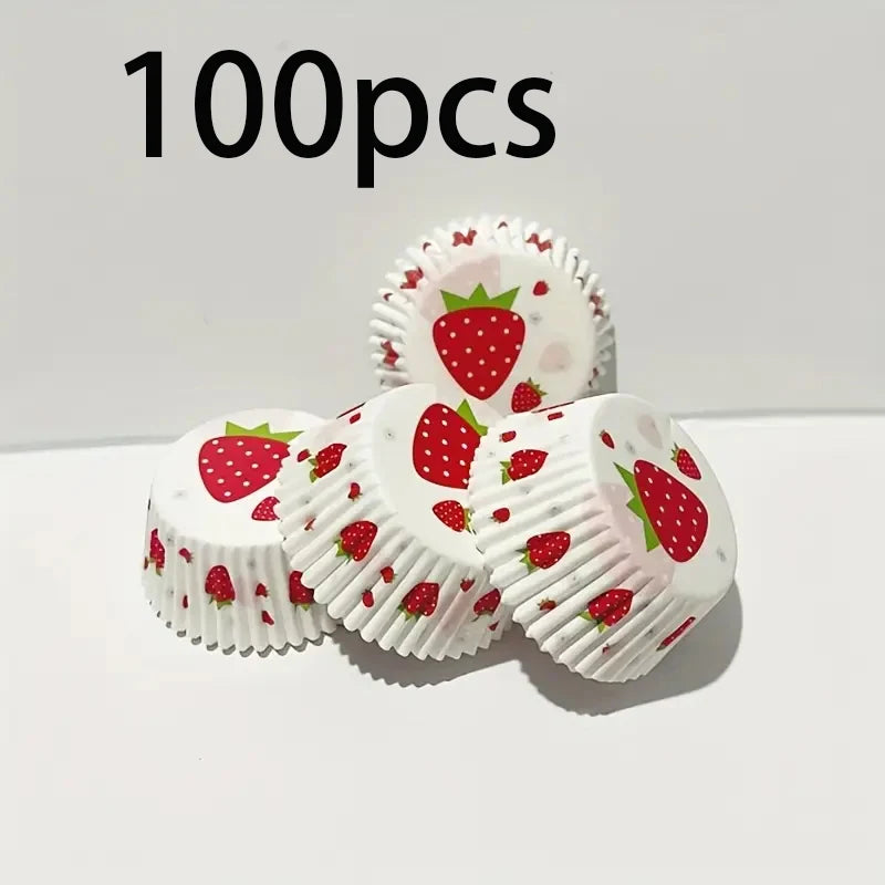 A collection of 100 oil-proof baking cups with a red strawberry pattern arranged on a white surface.