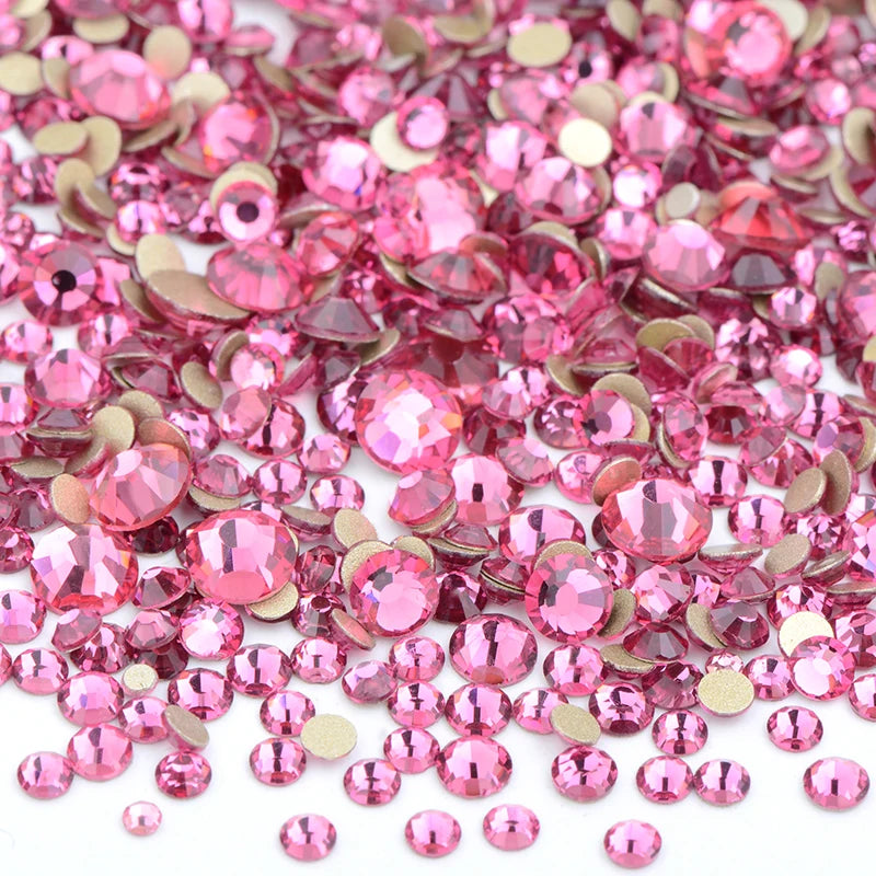 A pile of pink and clear glass rhinestones for DIY crafts