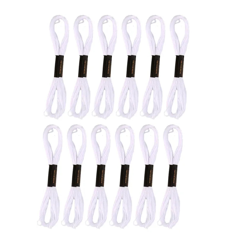 A set of white and black embroidery floss threads arranged vertically.