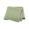 A light sage green knitted baby blanket with small holes for ventilation.