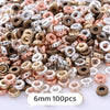 A close-up view of a mix of colorful geometric acrylic beads in various shades of gold, copper, and silver.