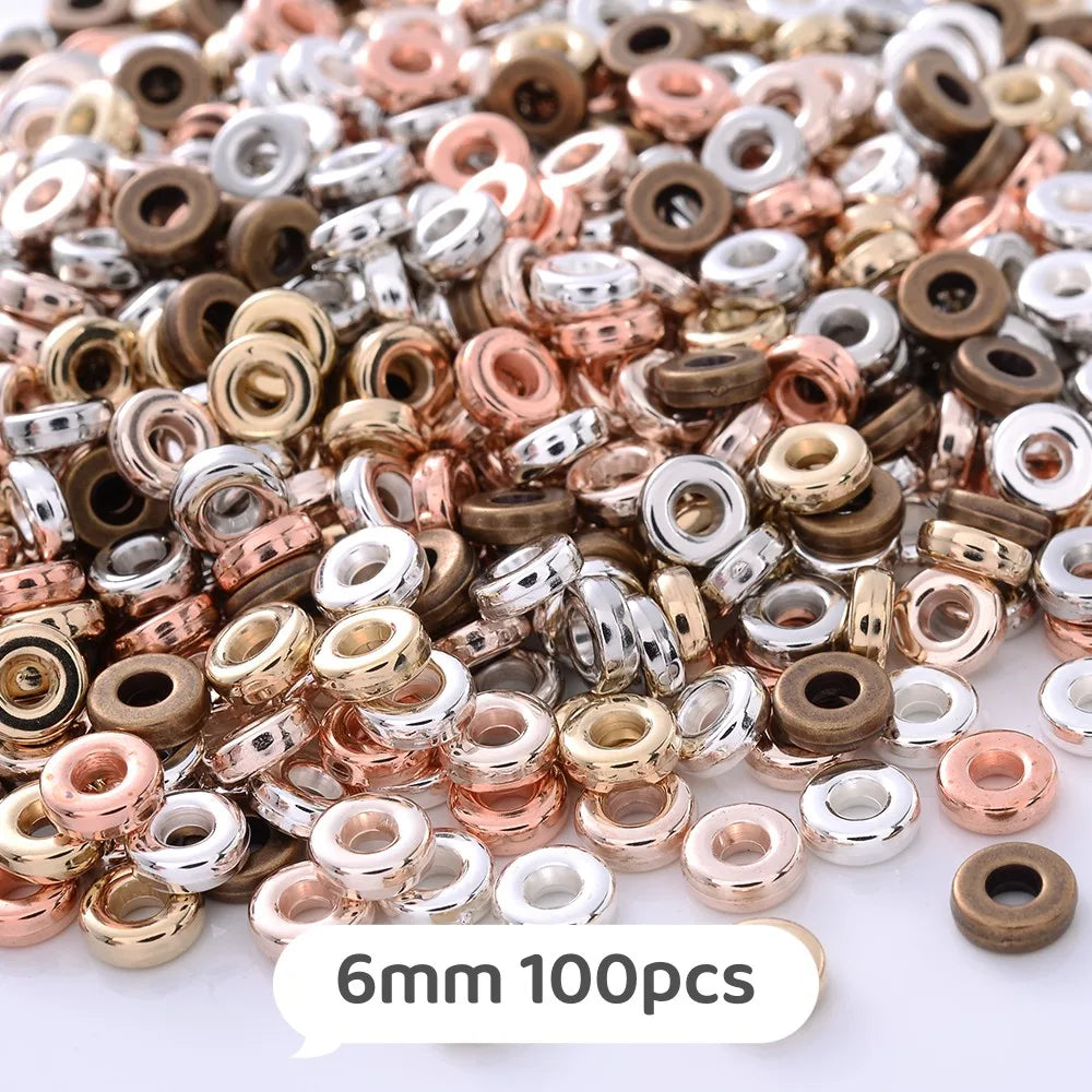 A close-up view of a mix of colorful geometric acrylic beads in various shades of gold, copper, and silver.