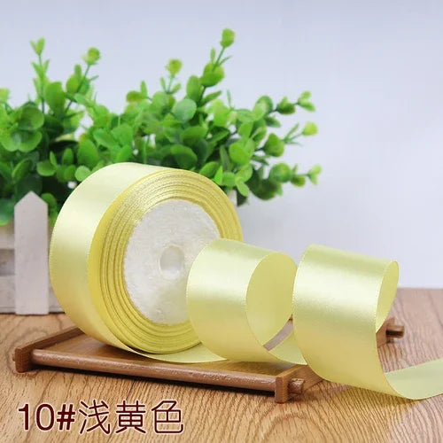 Roll of 4 cm wide satin ribbon in light yellow color for gift wrapping and DIY crafts