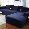 A deep navy velvet sofa cover for an L-shaped sectional sofa in a living room setting.
