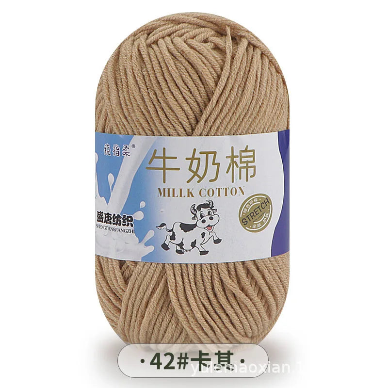A ball of beige milk cotton yarn with a label in Chinese and English.