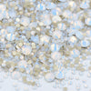 A pile of clear glass rhinestones in various sizes and shades of silver and iridescent blue for DIY crafts