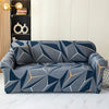 A modern gray sofa covered in a geometric pattern of dark blue and orange triangles.