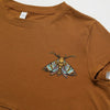 A brown t-shirt featuring an embroidered patch of a colorful moth on the chest.
