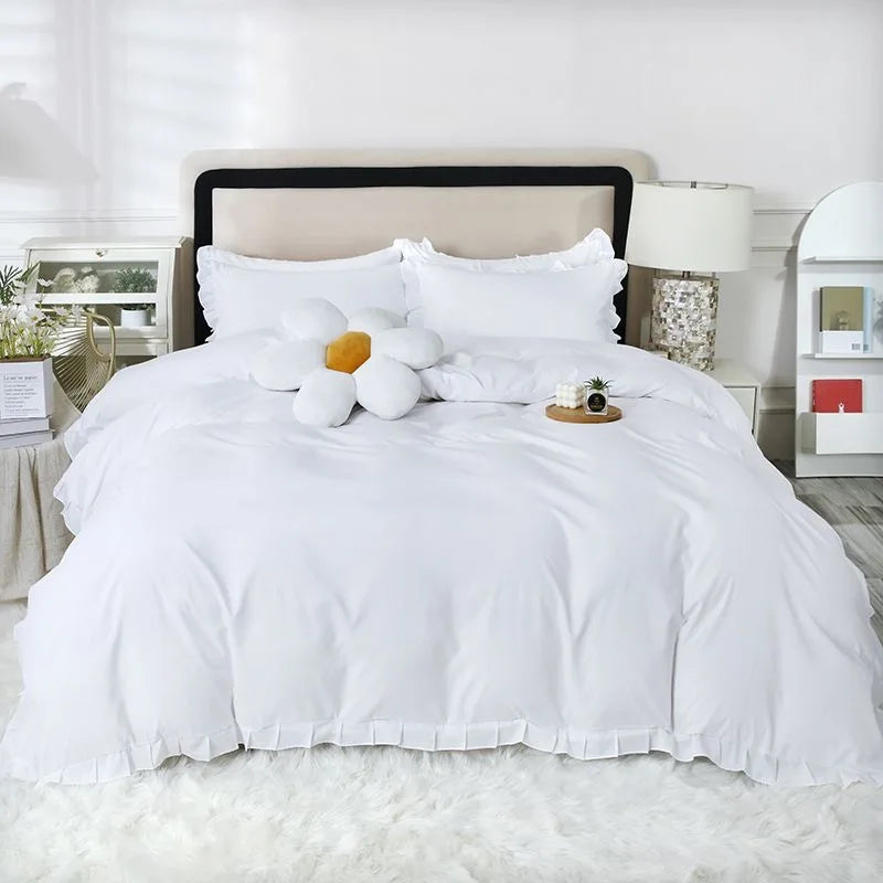 A white duvet with two white pillows and a yellow accent pillow on a bed with a neutral headboard.