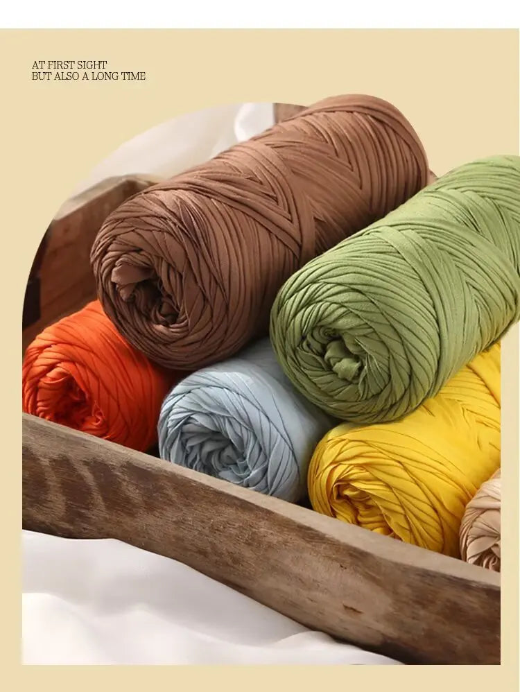 A collection of rolled reusable elastic yarn in various shades including brown, green, orange, blue, and yellow.