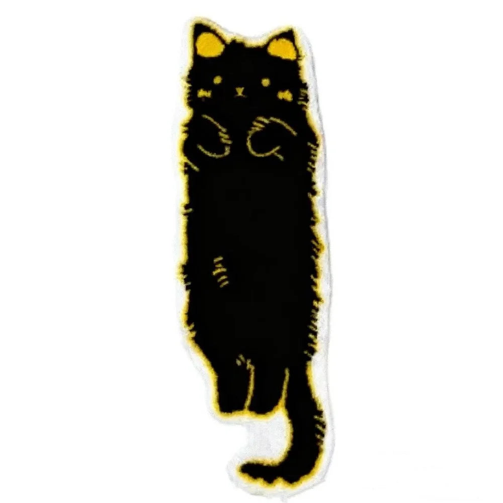 A black cartoon cat plush rug with yellow trim.