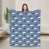 A blue flannel throw blanket featuring a repeating pattern of Jujutsu Kaisen Gojo Satoru masks.