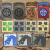 A collection of embroidered tactical patches featuring various symbols and designs on a camouflage background.