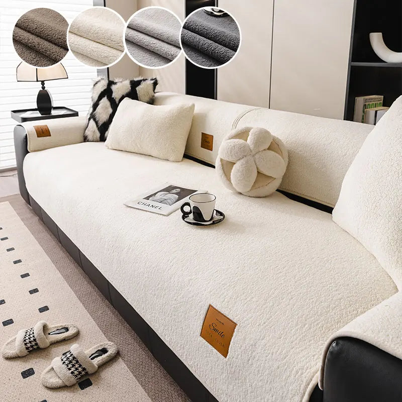 A cream colored multi-functional fleece sofa mat with decorative pillows and a small cup on the surface.