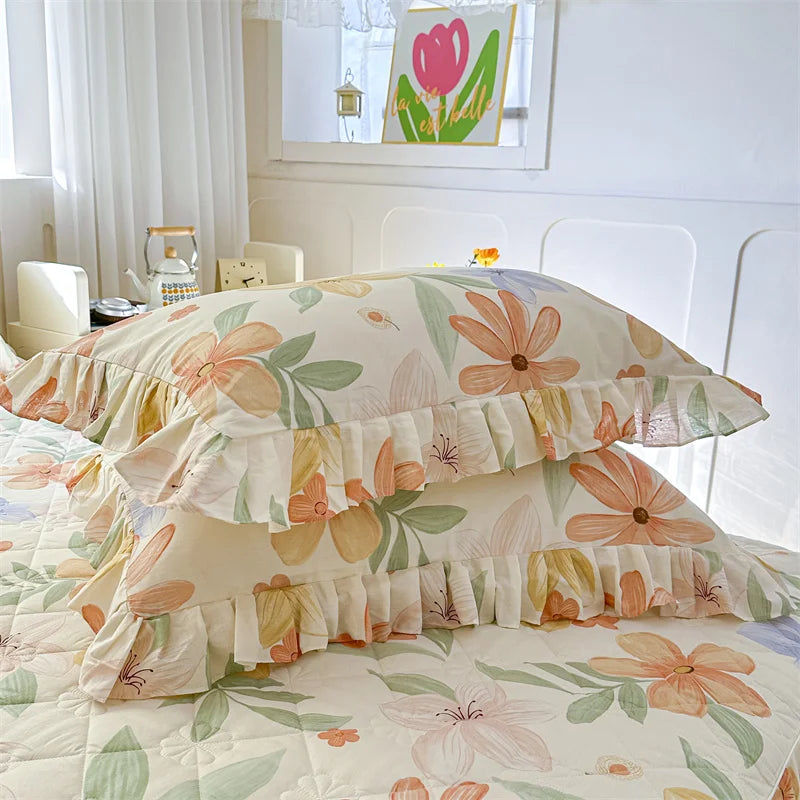 Two floral cotton pillow covers featuring pink and peach flowers and green leaves on a white background.