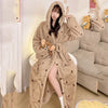 A woman wearing a beige leopard print flannel kimono robe indoors.