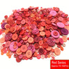 A pile of assorted resin sewing buttons in various shades of red and pink for crafting projects