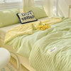 A light green Korean style seersucker summer quilt set with yellow accents and pillows on a bed.