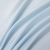 Soft light blue bamboo flat sheets draped in flowing fabric
