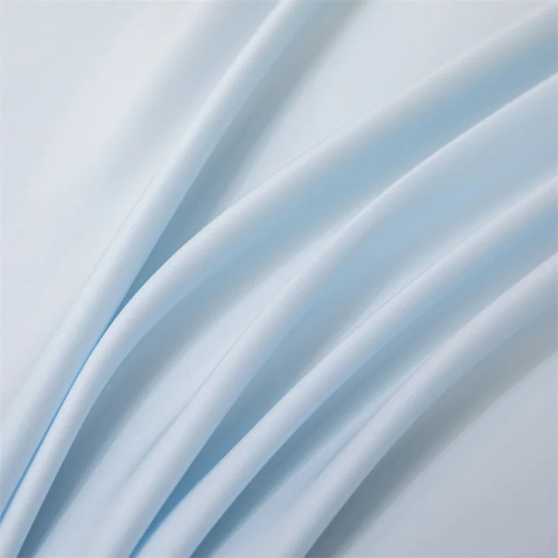 Soft light blue bamboo flat sheets draped in flowing fabric