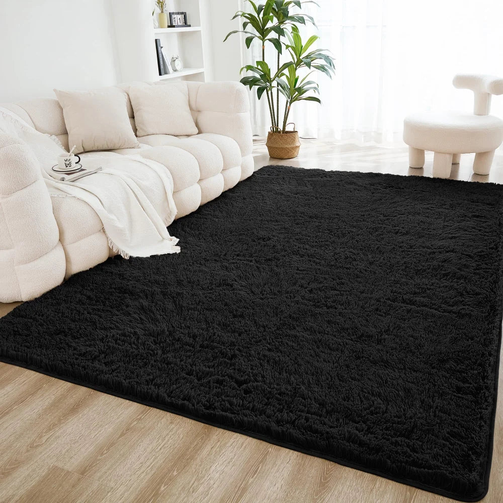 A black shaggy rug is placed on a light wood floor in a bright living room setting.