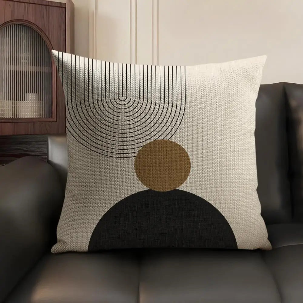 A beige cushion cover featuring minimalist geometric lines and a large circular brown shape on a dark background.
