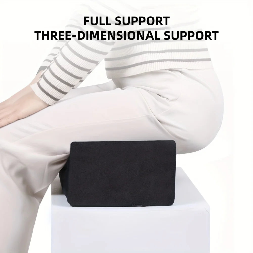 A person is sitting with a black ergonomic seat cushion placed on their lap, demonstrating three-dimensional support.