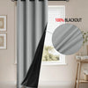 A single gray blackout privacy curtain hanging on a rod in a window frame.