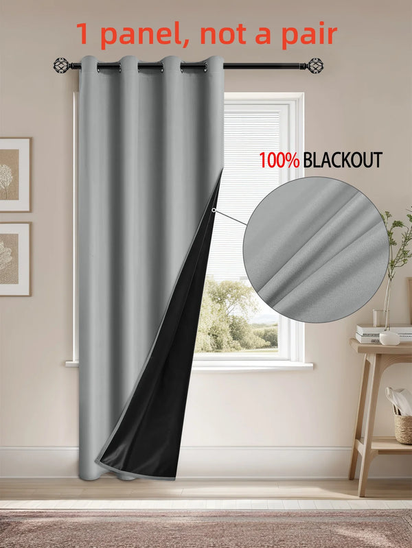 A single gray blackout privacy curtain hanging on a rod in a window frame.
