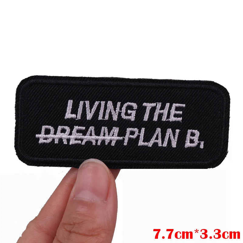 Black embroidered patch with white text LIVING THE DREAM PLAN B