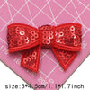 Red sequin bow patches for DIY decoration shown on a pink grid background
