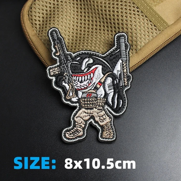 An embroidered patch featuring a fierce animal face with weapons for tactical gear or backpacks.