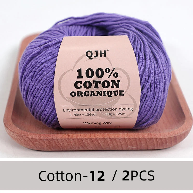 Purple QJH 100% organic cotton yarn skein displayed on a wooden tray.