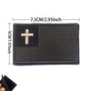 A rectangular dark brown embroidered patch featuring a white cross on a black background.