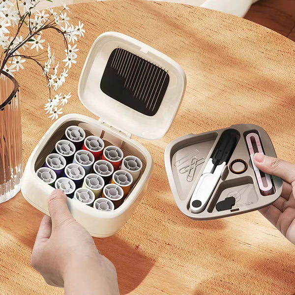 A hand opens a white magnetic sewing kit containing various specialty needles and thread on a wooden table.
