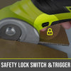 Close-up of a yellow and black rotary cutter with a safety lock switch and trigger cutting cardboard.