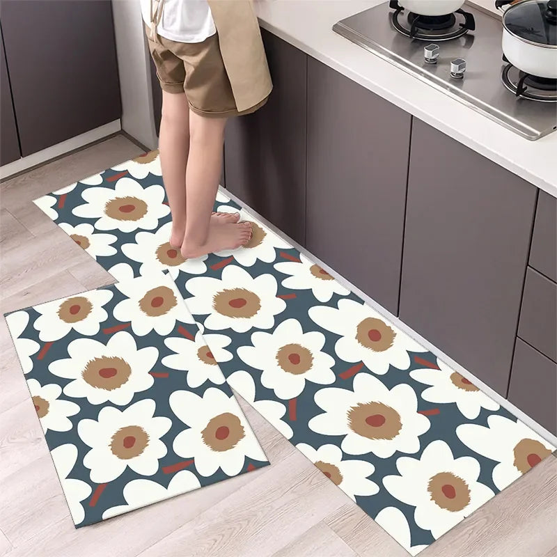 A set of two non-slip waterproof kitchen rugs with a diamond print featuring white and brown flowers on a light wood floor.