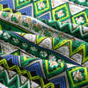 Close-up of bohemian printed linen fabric featuring geometric patterns in green, white, blue, and black.