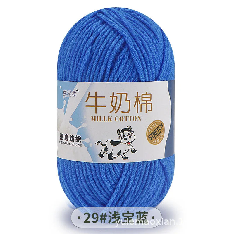 A ball of bright blue milk cotton yarn with a label in Chinese and English.