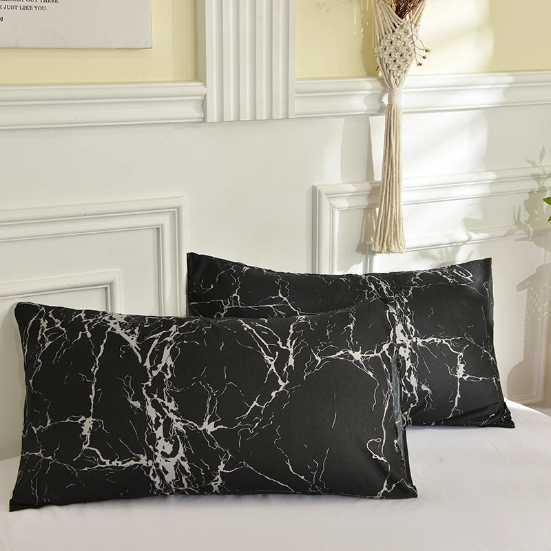 Black marble print duvet cover set with pillows on a white bed.