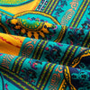 Close-up of vibrant teal and yellow bohemian printed linen fabric displaying intricate patterns.