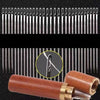A close-up view of a brown wooden tube containing a stainless steel sewing kit with multiple needles.