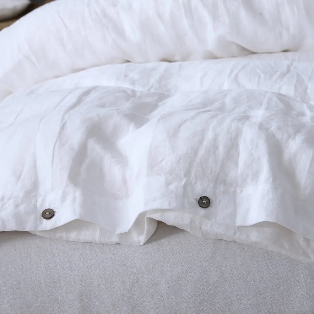 White luxury French linen duvet cover folded on a bed